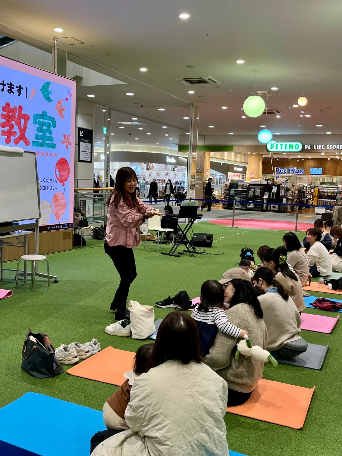 床に座って音楽遊びの道具を広げているレッスンの準備風景